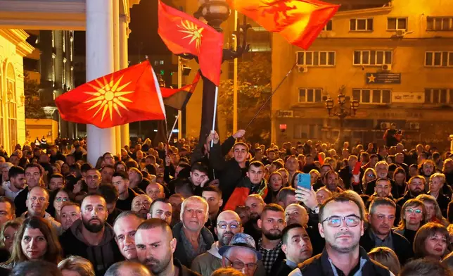 Supporters of the conservative VMRO-DPMNE party wave party flags and the old national flag as the leader Hristijan Mickoski announces a "great" victory in the local elections, at the party headquarters in Skopje, North Macedonia, on Sunday, Nov. 2, 2025. (AP Photo/Boris Grdanoski)