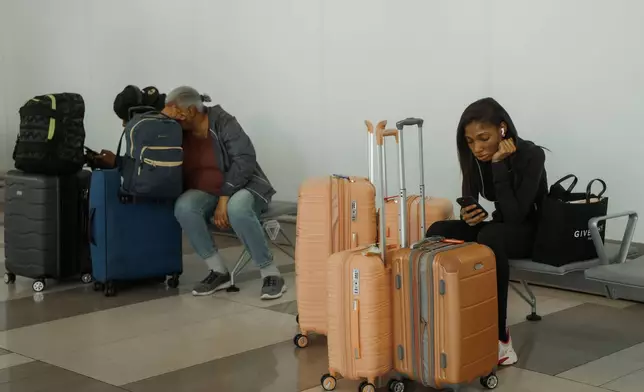 Travelers wait at LaGuardia International Airport in New York, Saturday, Nov. 8, 2025. (AP Photo/Olga Fedorova)