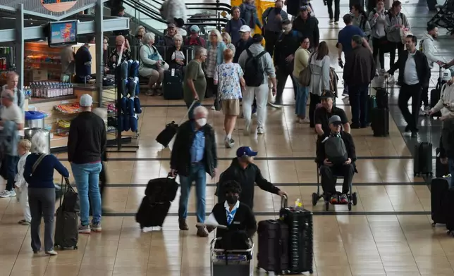 People make their way through a terminal at San Diego International Airport Saturday, Nov. 8, 2025, in San Diego. (AP Photo/Gregory Bull)