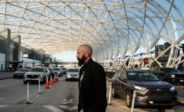 A passenger walks to Hartsfield-Jackson Atlanta International Airport, Friday, Nov. 7, 2025, in Atlanta. (AP Photo/Mike Stewart)