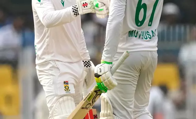 South Africa's Senuran Muthusamy, right, celebrates after scoring fifty runs with South Africa's Kyle Verreynne on the second day of the second cricket test match between India and South Africa in Guwahati, India, Saturday, Nov. 22, 2025. (AP Photo/Anupam Nath)