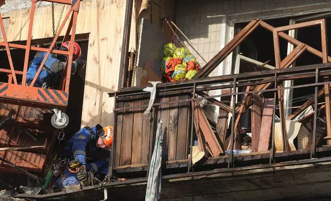 Rescuers work on the scene of a building damaged after a Russian attack in Kyiv, Ukraine, on Friday, Nov. 14, 2025. (AP Photo/Efrem Lukatsky)