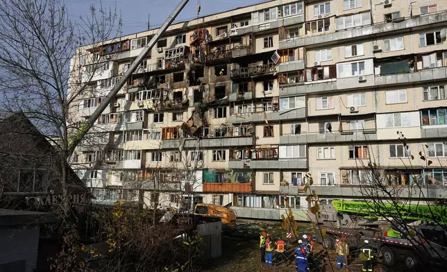 Rescuers work on the scene of a building damaged after a Russian attack in Kyiv, Ukraine, on Friday, Nov. 14, 2025. (AP Photo/Efrem Lukatsky)