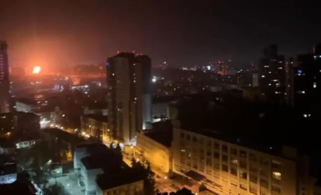 In this image taken from video, an explosion is seen in the distance as a Russian attack targets Ukraine's Kyiv region on Friday, Nov. 14, 2025.(AP Photo)