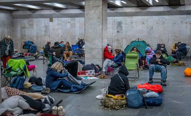People hide in a metro station, being used as a bomb shelter, during a Russian drones attack in Kyiv, Ukraine, early Friday, Nov. 14, 2025. (AP Photo/Dan Bashakov)