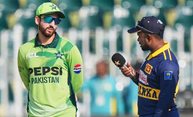 Pakistan's Salman Ali Agha, left, chats with Sri Lanka's Charith Asalanka as they wait for coin toss before the start of the second one day international cricket match between Pakistan and Sri Lanka, in Rawalpindi, Pakistan, Friday, Nov. 14, 2025. (AP Photo/Anjum Naveed)