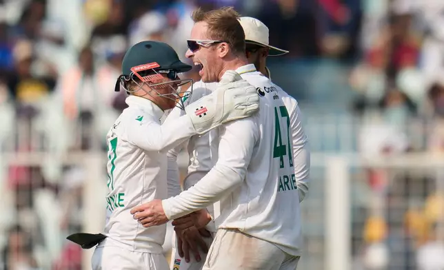South Africa's Simon Harmer, right, celebrates with teammates after the dismissal of India's Kuldeep Yadav on the third day of the first cricket test match between India and South Africa in Kolkata, India, Sunday, Nov. 16, 2025. (AP Photo/Aijaz Rahi)