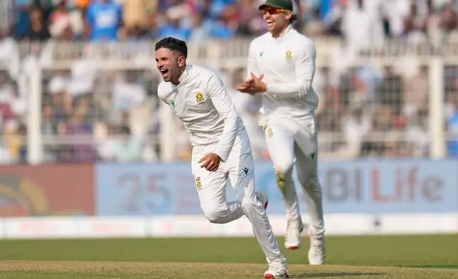 South Africa's Keshav Maharaj, left, celebrates after their win on the third day of the first cricket test match against India in Kolkata, India, Sunday, Nov. 16, 2025. (AP Photo/Aijaz Rahi)