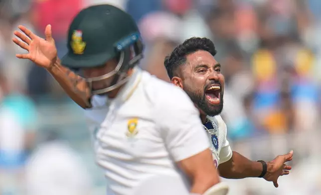 India's Mohammed Siraj celebrates the dismissal of South Africa's Keshav Maharaj, front, on the third day of the first cricket test match between India and South Africa in Kolkata, India, Sunday, Nov. 16, 2025. (AP Photo/Aijaz Rahi)