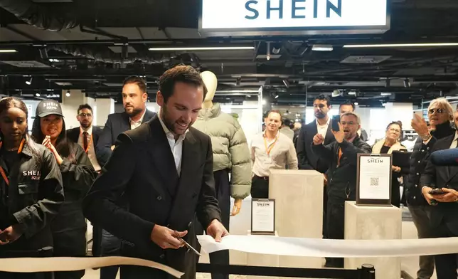 The director of the Bazar de l'Hotel de Ville (BHV) department store Karl-Stephane Cottendin cuts the ribbon at the opening Shein's first physical store in Paris, Wednesday, Nov. 5, 2025. ( Dimitar Dilkoff, Pool via AP)