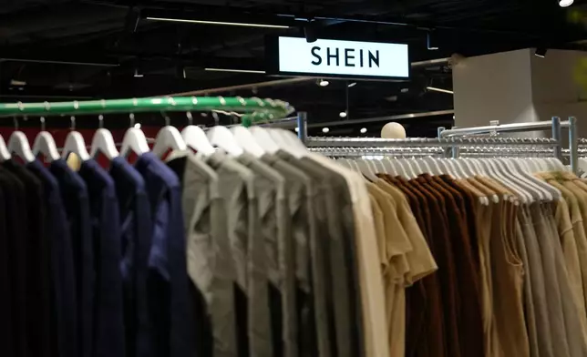Clothes by Chinese company Shein hang in the BHV (Bazar de l'Hotel de Ville) general store, ahead of the Shein stand opening, Tuesday, Nov. 4, 2025 in Paris. (AP Photo/Aurelien Morissard)