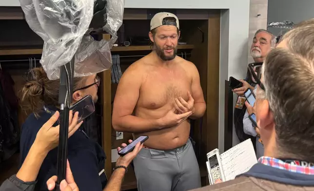 Clayton Kershaw, center, of the Los Angeles Dodgers addresses reporters for the last time as player after the Los Angeles Dodgers beat the Toronto Blue Jays 5-4 on Sunday, Nov. 2, 2025 in Toronto, Canada. (AP Photo/Rob Gillies)
