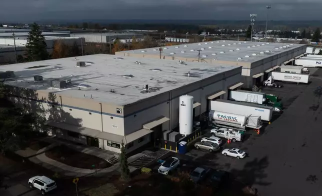 Vehicles are seen at a building that houses ByHeart, a manufacturer of organic baby formula, plant on Tuesday, Nov. 11, 2025, in Portland, Ore. (AP Photo/Jenny Kane)