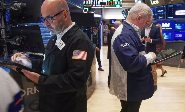 Traders Fred Demarco, left, and Edward McCarthy work on the floor of the New York Stock Exchange, Monday, Nov. 24, 2025. (AP Photo/Richard Drew)