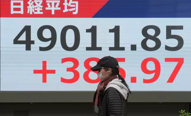 A person walks in front of an electronic stock board showing Japan's Nikkei index at a securities firm Tuesday, Nov. 25, 2025, in Tokyo. (AP Photo/Eugene Hoshiko)