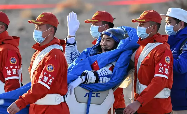 In this photo released by Xinhua News Agency, Chen Zhongrui, a Shenzhou-20 astronaut, is carried out from the Shenzhou-21 spaceship's return capsule after it touched down on Earth at the Dongfeng landing site in northern China's Inner Mongolia Autonomous region on Friday, Nov. 14, 2025. (Li Zhipeng/Xinhua via AP)