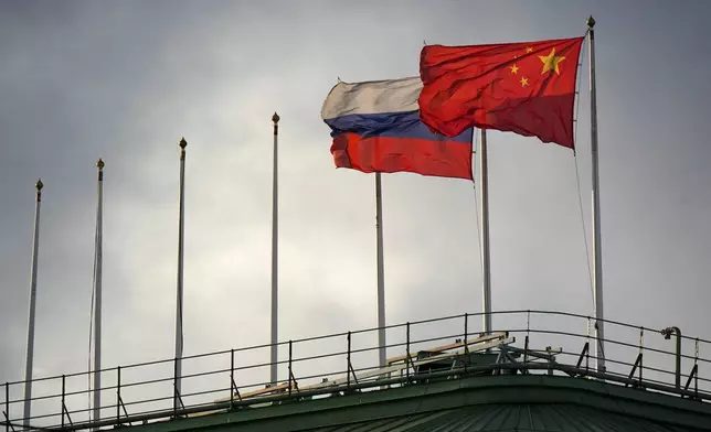 The flags of Russia and China flutter on the roof of a hotel with the flags of other countries removed, in central St. Petersburg, Russia, Friday, Nov. 14, 2025. (AP Photo/Dmitri Lovetsky)