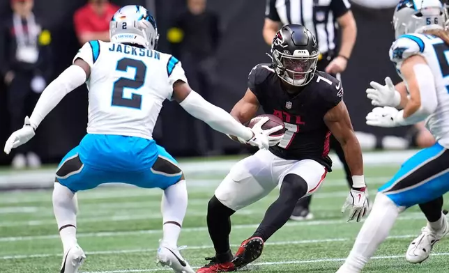 Atlanta Falcons running back Bijan Robinson (7) carries against Carolina Panthers cornerback Mike Jackson (2) in the first half of an NFL football game, Sunday, Nov. 16, 2025, in Atlanta. (AP Photo/Mike Stewart)
