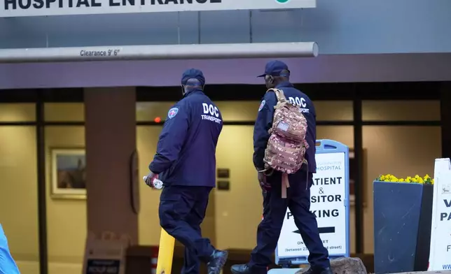 Employees of the Department of Corrections arrive to enter the George Washington University Hospital, Wednesday, Nov. 26, 2025 in Washington. (AP Photo/Evan Vucci)
