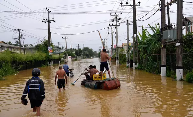 People use a crude raft to navigate a flooded street in Colombo, Sri Lanka, Saturday, Nov. 29, 2025. (AP Photo/Eranga Jayawardena)