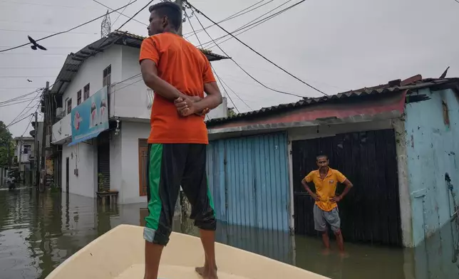 A volunteer searches for needy people in a flooded area in Colombo, Sri Lanka, Saturday, Nov, 29, 2025. (AP Photo/Eranga Jayawardena)
