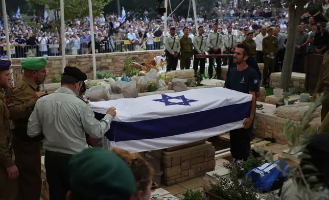 Israeli soldiers attend the funeral of late Israeli hostage soldier Hadar Goldin in Kfar Saba, Israel, Tuesday, Nov. 11, 2025, who was killed in 2014 and his body returned as part of the current ceasefire deal between Israel and Hamas. (Abir Sultan/Pool Photo via AP)