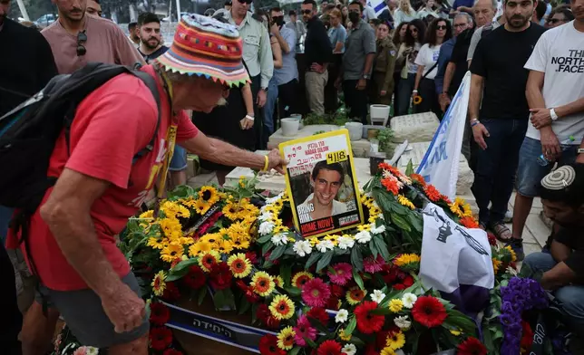 People mourn at the grave of Hadar Goldin an Israeli soldier killed in Gaza in 2014 and whose body had been held there until it was released Sunday, during his funeral in Kfar Saba, Israel, Tuesday, Nov. 11, 2025. (Abir Sultan/Pool via AP)