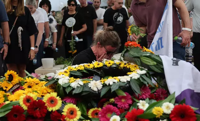 People mourn at the grave of Hadar Goldin an Israeli soldier killed in Gaza in 2014 and whose body had been held there until it was released Sunday, during his funeral in Kfar Saba, Israel, Tuesday, Nov. 11, 2025. (Abir Sultan/Pool via AP)