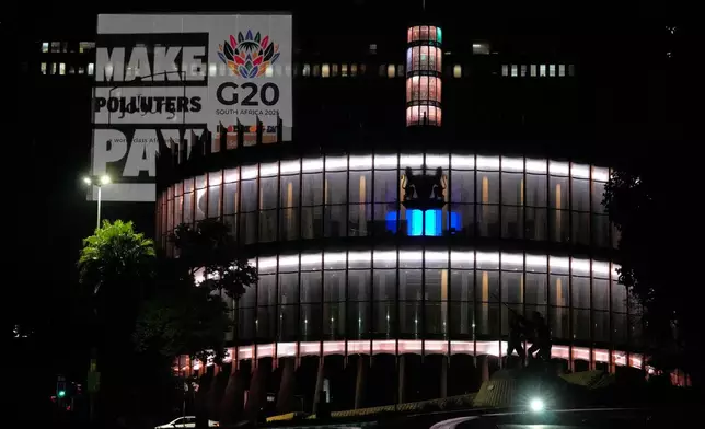 A series of bold, high-visibility nighttime projections of "Make Polluters Pay" campaign by Glasgow Actions Team, at the Joburg Council Chamber building, in Johannesburg, South Africa, Wednesday, Nov. 19, 2025. (AP Photo/Themba Hadebe)