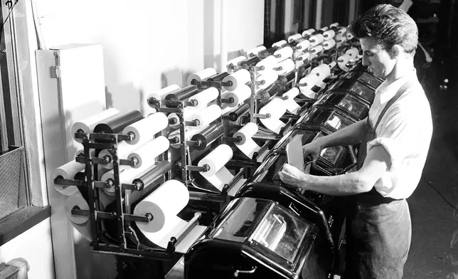 FILE - An Associated Press staffer reads copy from the election tabulator, Nov. 1936. (AP Photo, File)
