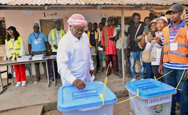 In this photo released by the Communication office Presidency republic of Guinea Bissau, incumbent President Umaro Sissoco Embalo casts his votes at a polling station during the Presidential and legislative elections in Bissau, Guinea-Bissau, Sunday, Nov. 23, 2025. (Communication office Presidency republic of Guinea Bissau via AP)