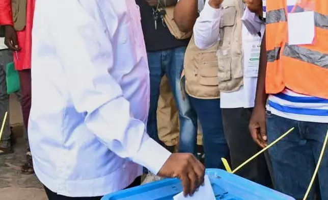 In this photo released by the Communication office Presidency republic of Guinea Bissau, incumbent President Umaro Sissoco Embalo casts his votes at a polling station during the Presidential and legislative elections in Bissau, Guinea-Bissau, Sunday, Nov. 23, 2025. (Communication office Presidency republic of Guinea Bissau via AP)