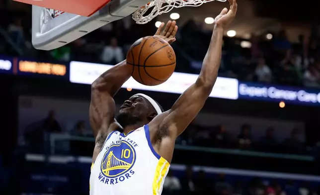 Golden State Warriors forward Jimmy Butler III slam dunks the ball during the second quarter of an NBA basketball game against the New Orleans Pelicans, Sunday, Nov. 16, 2025, in New Orleans. (AP Photo/Butch Dill)