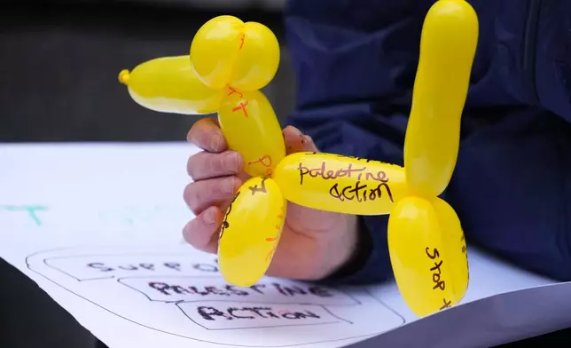 A protester holds a balloon animal outside the Home Office during a Palestine Action demonstration in London, Monday, Nov. 24, 2025. (AP Photo/Kirsty Wigglesworth)