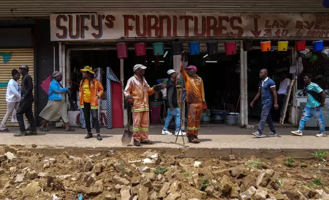 Workers fix a road in Johannesburg's Soweto township as a massive cleanup job gets underway in anticipation of the upcoming G20 summit to be held in the South African economic capital, Friday, Nov. 14, 2025. (AP Photo/Jerome Delay)