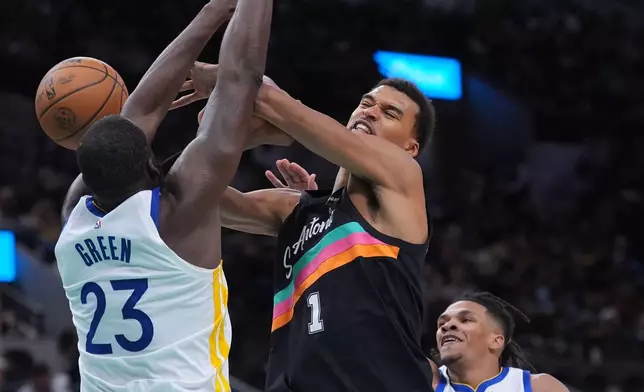 San Antonio Spurs forward Victor Wembanyama (1) is fouled by Golden State Warriors forward Draymond Green (23) during the second half of an NBA basketball game in San Antonio, Wednesday, Nov. 12, 2025. (AP Photo/Eric Gay)