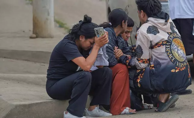 Relatives of prisoners who died during clashes between inmates wait for the remains of their loved ones outside the morgue in Machala, Ecuador, Monday, Nov. 10, 2025. (AP Photo/Cesar Munoz)