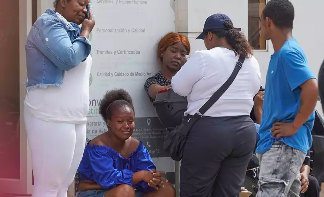 The relatives of prisoners who died during a clashes between inmates wait for the remains of their loved ones outside the morgue in Machala, Ecuador, Monday, Nov. 10, 2025. (AP Photo/Cesar Munoz)