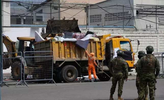 Workers remove belongings from the prison where inmates were killed during clashes between themselves in Machala, Ecuador, Monday, Nov. 10, 2025. (AP Photo/Cesar Munoz)
