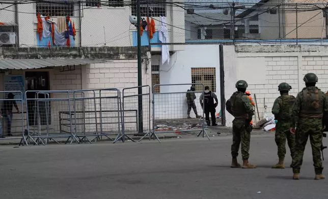 Soldiers stand guard outside the prison where inmates were killed during clashes between themselves in Machala, Ecuador, Monday, Nov. 10, 2025. (AP Photo/Cesar Munoz)