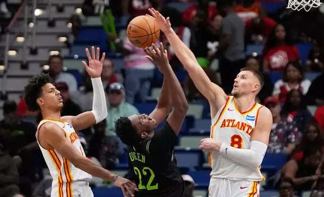 New Orleans Pelicans center Derik Queen (22) battles near the basket between Atlanta Hawks center Kristaps Porzingis (8) and forward Jalen Johnson (1) in the second half of an NBA basketball game, Saturday, Nov. 22, 2025, in New Orleans. (AP Photo/Gerald Herbert)