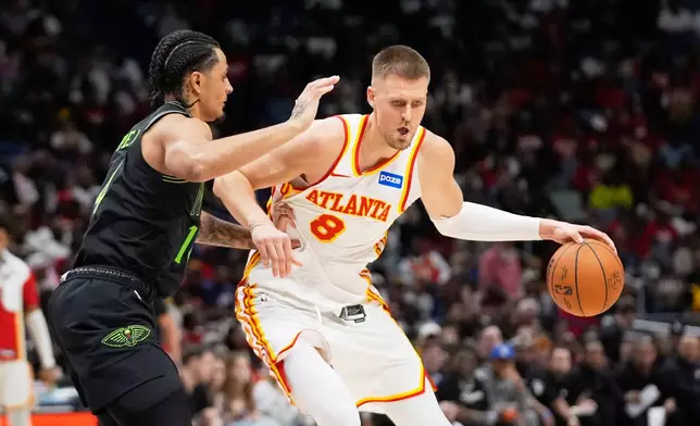 Atlanta Hawks center Kristaps Porzingis (8) moves the ball against New Orleans Pelicans guard Micah Peavy in the second half of an NBA basketball game, Saturday, Nov. 22, 2025, in New Orleans. (AP Photo/Gerald Herbert)