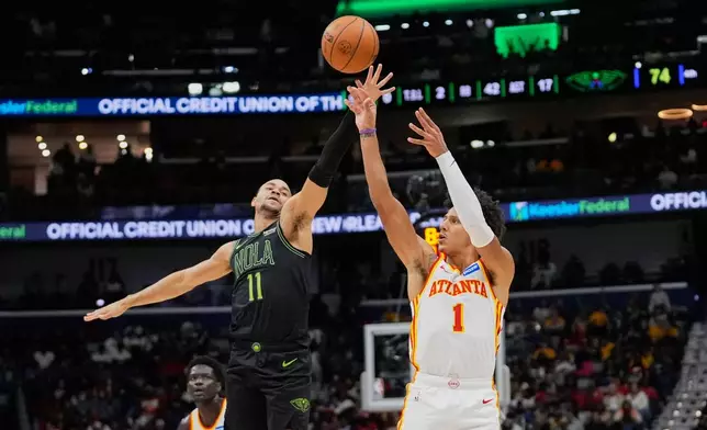 Atlanta Hawks forward Jalen Johnson (1) shoots against New Orleans Pelicans guard Bryce McGowens (11) in the second half of an NBA basketball game, Saturday, Nov. 22, 2025, in New Orleans. (AP Photo/Gerald Herbert)