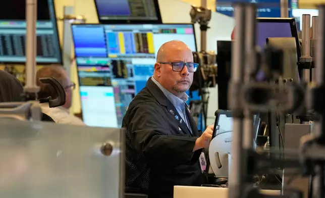 Jeff Vazquez works on the floor at the New York Stock Exchange in New York, Tuesday, Nov. 11, 2025. (AP Photo/Seth Wenig)
