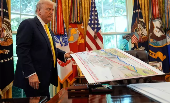 FILE - President Donald Trump holds a chart as he discusses the economy in the Oval Office of the White House, Aug. 7, 2025, in Washington. (AP Photo/Mark Schiefelbein, File)
