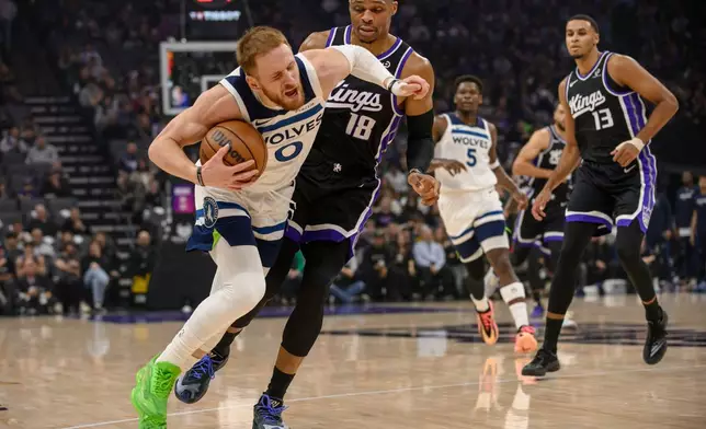 Minnesota Timberwolves guard Donte DiVincenzo (0) is guarded by Sacramento Kings guard Russell Westbrook (18) during the first half of an NBA basketball game in Sacramento, Calif., Monday, Nov. 24, 2025. (AP Photo/Randall Benton)