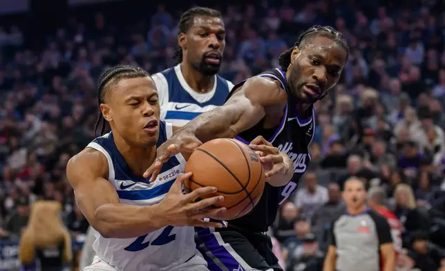 Minnesota Timberwolves guard Jaylen Clark, left, and Sacramento Kings forward Precious Achiuwa (9) battle for a rebound during the first half of an NBA basketball game in Sacramento, Calif., Monday, Nov. 24, 2025. (AP Photo/Randall Benton)