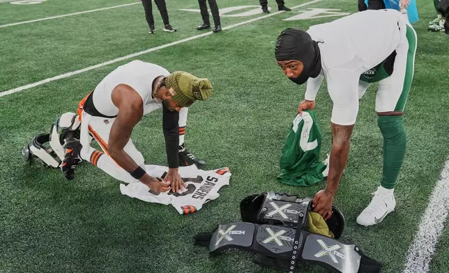 Cleveland Browns quarterback Shedeur Sanders, left, and New York Jets quarterback Tyrod Taylor, right, exchange jerseys after their NFL football game, Sunday, Nov. 9, 2025, in East Rutherford, N.J. (AP Photo/Seth Wenig)