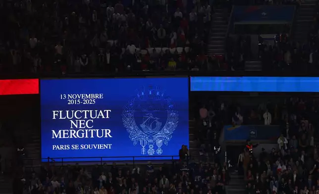 A screen reading Paris' motto "It is rocked by the waves, but does not sink" during a minute of silence in tribute for the victims of the Nov.13, 2015 Paris attacks, ahead of the 2026 World Cup qualifiers Europe zone group D football match between France and Ukraine at the Parc des Princes stadium, Thursday, Nov. 13, 2025 in Paris. ( Franck Fife, Pool photo via AP)