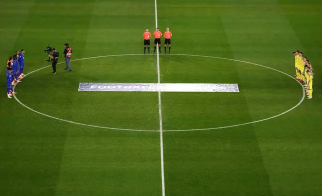 Ukrainian, right, and French players observe a minute of silence in tribute to the victims of the Nov.13, 2015 Paris attacks, ahead of the 2026 World Cup qualifiers Europe zone group D football match between France and Ukraine at the Parc des Princes stadium, Thursday, Nov. 13, 2025 in Paris. ( Franck Fife, Pool photo via AP)